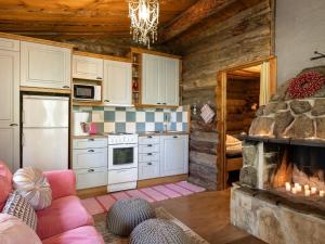 a kitchen with a living room with a fireplace at Holiday Home Rinnekämppä by Interhome in Pätiälä