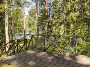 two chairs and a table on a wooden deck at Holiday Home Rinnekämppä by Interhome in Pätiälä