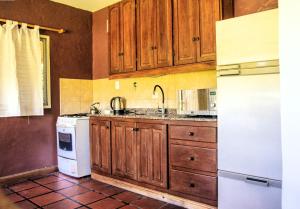 a kitchen with wooden cabinets and a white refrigerator at Casa Quinta Matilda Gon in Chascomús
