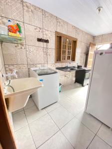 bagno con lavandino e frigorifero di Casa para família e amigos na praia a Pontal do Paraná