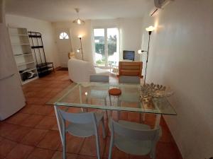 a living room with a glass table and chairs at villa 2 chambres en rez-de-jardin in Puylaurens