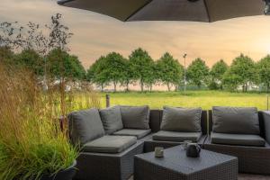 a patio with a couch and a table and an umbrella at Inn Hantum in Hantum