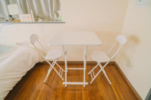 a table and two chairs next to a bed at MinamiFukuokaHouse in Fukuoka +67 photos