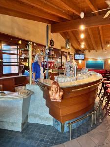 a woman standing at a bar in a restaurant at Piccola Italia Residence - Tremosine sul Garda in Tremosine Sul Garda +15 photos