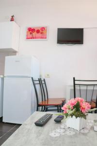 een keuken met een tafel met twee afstandsbedieningen bij Willy Apartments in Velipojë