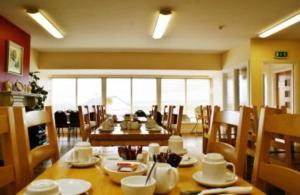 a dining room with a table with chairs and a tableasteryasteryasteryasteryastery at Teach Greannaí Cabin in Curraunboy