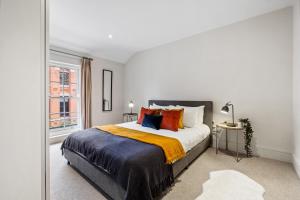 a bedroom with a large bed with orange and blue pillows at Osbourne House - BLUE 2 Bedroom,2 and half bath in Birmingham