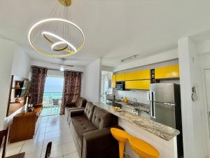 cocina y sala de estar con sofá y nevera en Edifício Baalbek, en Mongaguá