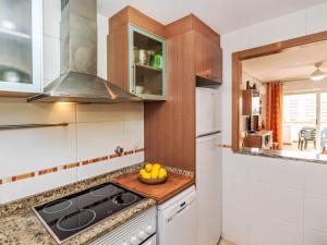 a kitchen with a stove and a bowl of fruit on a counter at Apartment La Mar Bella by Interhome in El Borseral