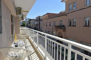 a balcony with tables and chairs on a building at Poli's Luxury suite @ N. Moudania in Nea Moudania