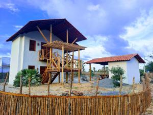 a house with a wooden fence in front of it at Casa Vento Parte Baixa in Luis Correia