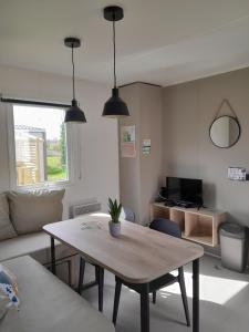 a living room with a table and a couch at Camping proche Bayeux et Omaha Beach in Tournières