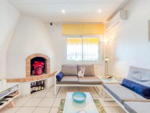a living room with a couch and a fireplace at Holiday Home Green House by Interhome in Empuriabrava