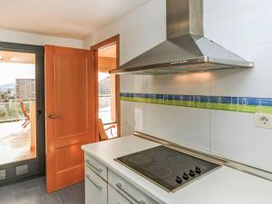 a kitchen with a stove top oven next to a balcony at Apartment Las Terrazas- La Marina-1 by Interhome in Oropesa del Mar