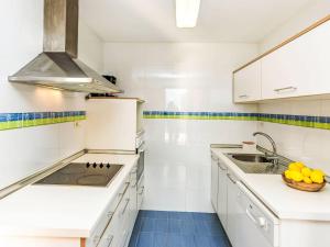 a kitchen with white cabinets and a sink and a bowl of fruit at Apartment Las Terrazas- La Marina-1 by Interhome in Oropesa del Mar +19 photos
