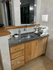 un bancone della cucina con lavandino e finestra di Casa no Perequê a 300 metros da praia - Espaço inteiro a Ilhabela