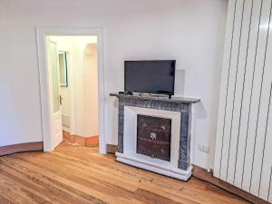 a living room with a fireplace with a tv on top at Apartment Blu - Borgo Antico by Interhome in Porto Valtravaglia +25 photos