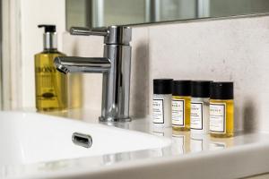 four bottles of oils sitting on a bathroom sink at Osbourne House - BLUE 2 Bedroom,2 and half bath in Birmingham +72 photos