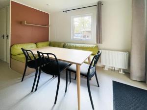 a dining room with a table and chairs and a couch at Holiday Home De Brenkberg-1 by Interhome in Schinveld +16 photos