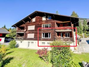 a wooden house with a red box in front of it at Apartment SnowKaya Grindelwald by Interhome in Grindelwald