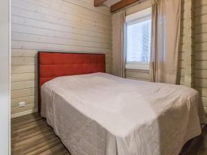 Schlafzimmer mit einem Bett mit einem roten Kopfteil und einem Fenster in der Unterkunft Holiday Home Uulanlinna a- paritalo by Interhome in Hyrynsalmi + 38 Fotos