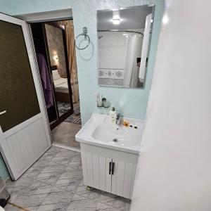 a bathroom with a white sink and a mirror at Hotel Jasmina in Samarkand