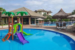 a swimming pool with a slide in a resort at VG Sun Cumbuco Térreo WiFi Ar Cond 4 Pessoas in Paracumbuca