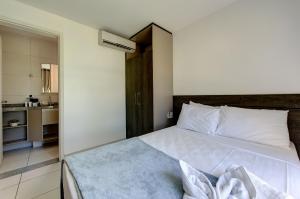 a bedroom with a large white bed in a room at VG Sun Cumbuco Térreo WiFi Ar Cond 4 Pessoas in Paracumbuca +34 photos