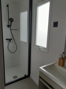 a white bathroom with a shower and a sink at Camping proche Bayeux et Omaha Beach in Tournières +62 photos