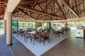 a dining room with tables and chairs in a building at VG Sun Cumbuco Térreo WiFi Ar Cond 4 Pessoas in Paracumbuca