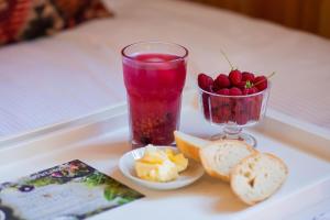 a tray with a drink and a bowl of fruit at Old Garden in Sycewo