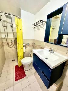 une salle de bain avec un lavabo, des toilettes et une douche dans l'établissement HOMEY STAYCATION WITH PARKING near Diliman, Katipunan, Commonwealth, à Manille