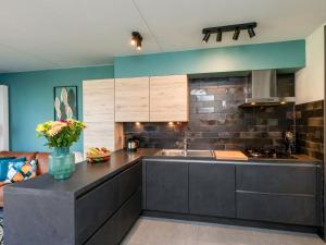 eine Küche mit einer Theke und einem Waschbecken in einem Zimmer in der Unterkunft Holiday Home Solipi by Interhome in Nieuwvliet-Bad