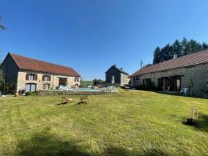 a yard with two buildings and a table in the grass at Domaine Pâquerettes et Pïssenlits in Le Pommier