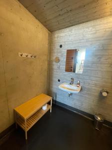 a bathroom with a sink and a wooden bench at Støkkøya Strandhotell in Hosen +52 photos
