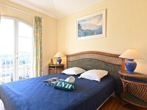 Holiday Home Village Cap Estérel - Le Hameau-36 by Interhome في Drammont: غرفة نوم بسرير ازرق مع مخدات ونافذة