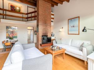 a living room with white couches and a fireplace at Holiday Home Zonnehof Nieuwvliet-Bad by Interhome in Nieuwvliet-Bad