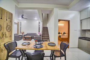 une salle à manger et un salon avec une table et des chaises dans l'établissement Southgate Villa Hotel near Bangalore International Airport, à Muthugadahalli