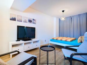 Una sala de estar con televisión y un sofá. en Apartment Hašlerka by Interhome, en Janov nad Nisou