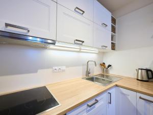 Una cocina con gabinetes blancos y un fregadero. en Apartment Hašlerka by Interhome, en Janov nad Nisou