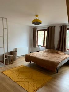 ein Schlafzimmer mit einem großen Bett und einem gelben Teppich in der Unterkunft Guanto vakantiewoning in Ronse