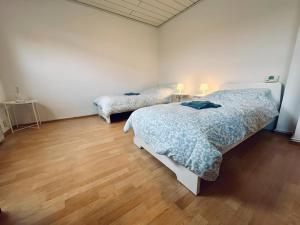 a bedroom with two beds and a wooden floor at sleepWELL-Steinfurt IV Wintergarten & Platz in Steinfurt