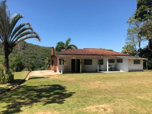 a house with a palm tree in the yard at Casa em Penedo - Itatiaia in Itatiaia