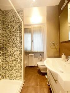 a bathroom with a toilet and a sink and a shower at Appartamento AL SOLE a Marina di Cecina by Zoom In Earth in Marina di Cecina