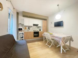 a kitchen and dining room with a table and chairs at Appartamento AL SOLE a Marina di Cecina by Zoom In Earth in Marina di Cecina