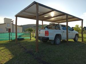 a white truck parked under a tent in a field at Lafiaca in Sierra de la Ventana