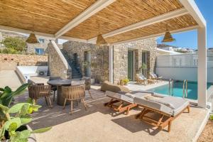 a patio with a table and chairs and a pool at Villa Gypsea - Paros in Aspro Chorio Paros