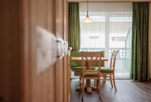 a dining room with a table and chairs and a window at Hotel Sureghes in Ortisei