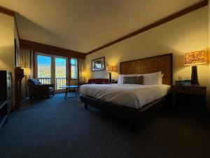ein Hotelzimmer mit einem großen Bett und einem Stuhl in der Unterkunft Ski In Ski Out Stowe Studio at Spruce Peak in Stowe