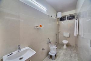 une salle de bain blanche avec un lavabo et des toilettes dans l'établissement Southgate Villa Hotel near Bangalore International Airport, à Muthugadahalli